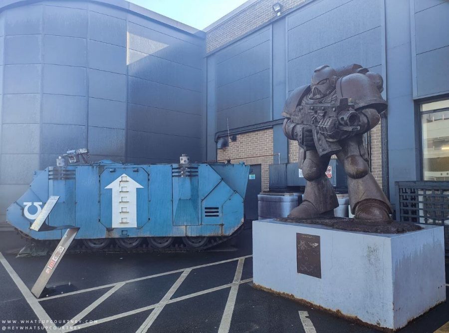 A big statue of a space marine and a Rhino tank engine outside of the Warhammer World