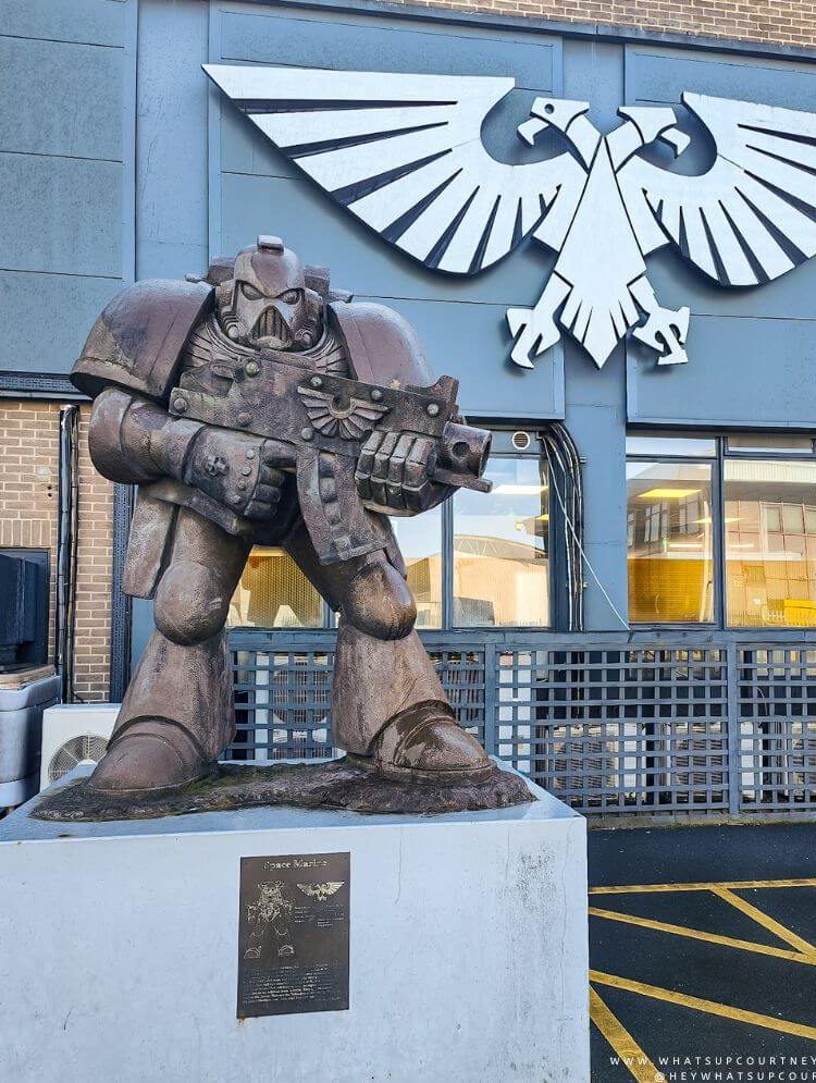A statue of a space marine and logo of Warhammer outside of the Warhammer world in Nottingham