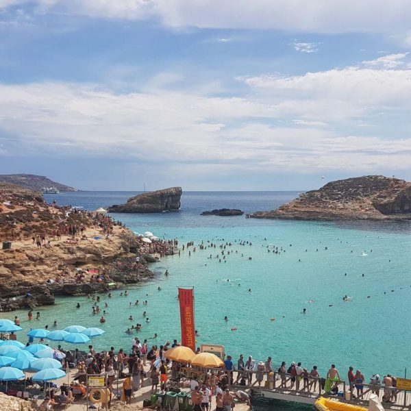 Blue grotto with blue sea and crowded beach in Malta