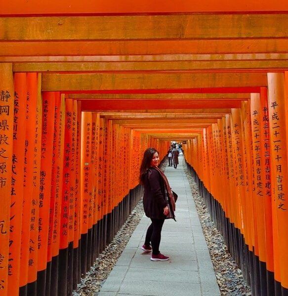 Courtney from whatsupcourtney (heywhatsupcourtney) posing in the middle of the Fushimi Inari Torii gates kyoto