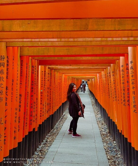 Courtney from whatsupcourtney (heywhatsupcourtney) posing in the middle of the Fushimi Inari Torii gates kyoto