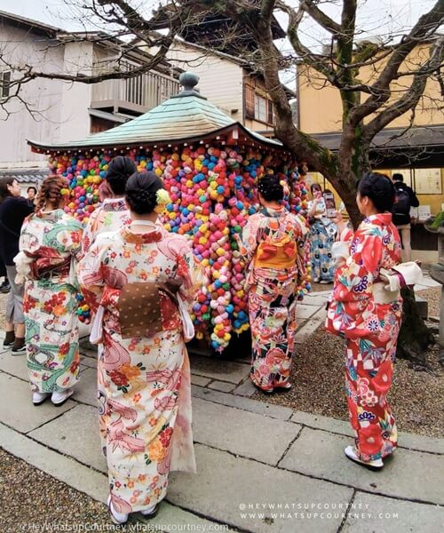 Ladies dressed in Kimono excitedly making wishes at Yasaka Kōshin-dō in Kyoto, one of things to do in Kyoto