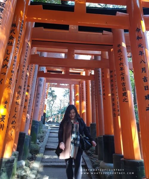 Courtney walking through the famous red or orange Torii Gates in Fushimi Inari Kyoto