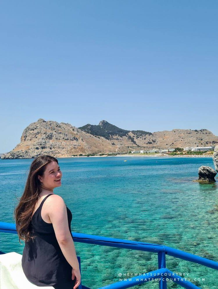 Courtney from whatsupcourtney.com by a church and beach in Rhodes Greece