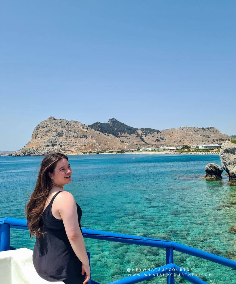 Courtney from whatsupcourtney.com by a church and beach in Rhodes Greece