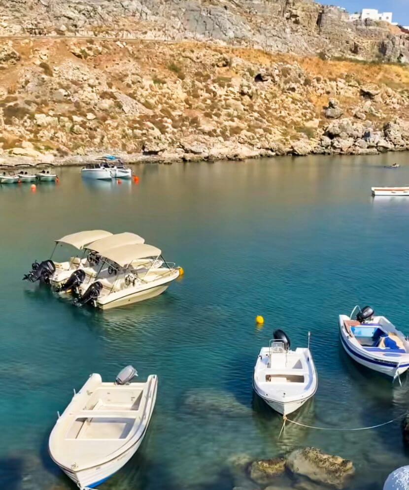 boats and speedboats bobbing at st pauls bay in lindos greece